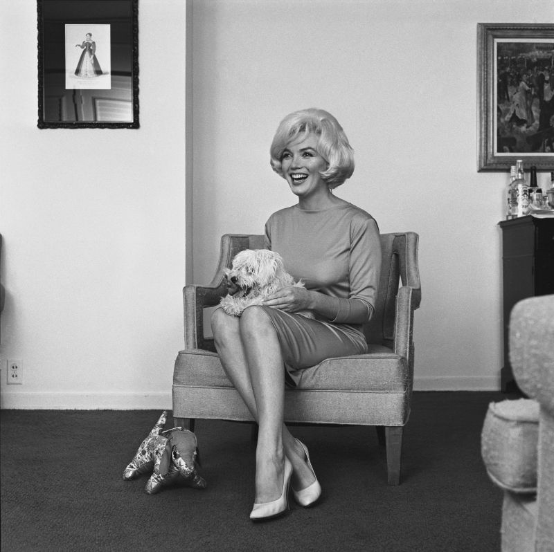 Marilyn Monroe con le scarpe di Salvatore Ferragamo Décolleté, 1961, raso rosa, insieme al cane Maf Honey , Hotel Beverly Hills, 1961. © Eric Skipsey / mptvimages.com